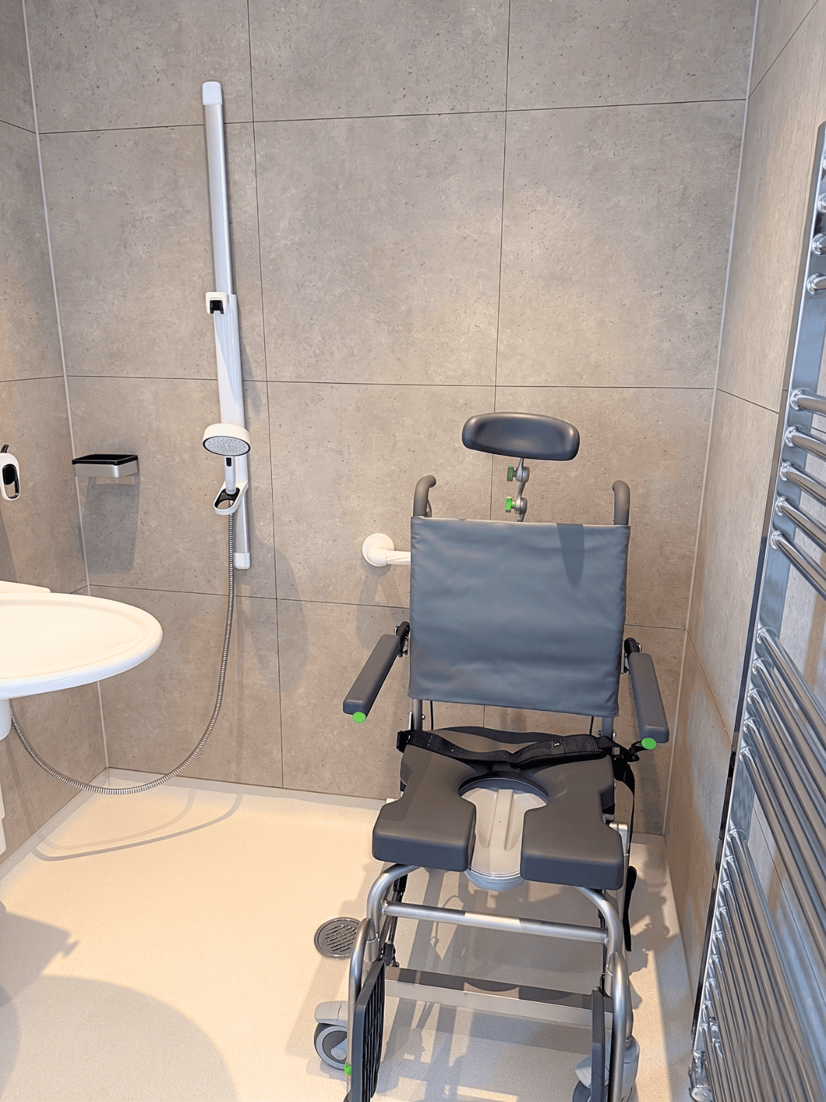 Level-access wet room shower with grab rails and fold-down seat